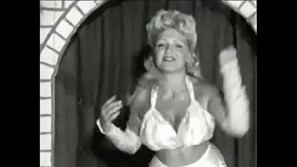 Curly blonde with huge tits takes part in an erotic performance_of the 60s