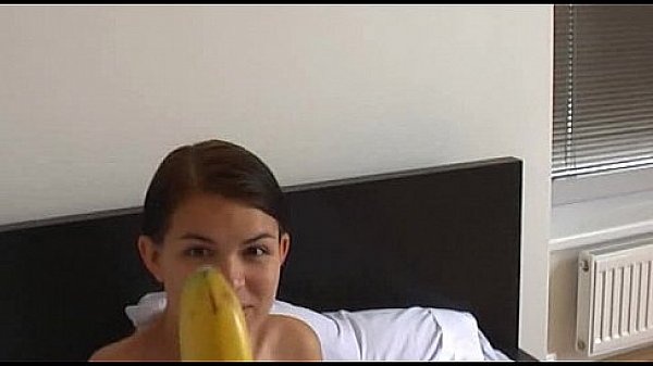 How young brunette girl teaches using a banana
