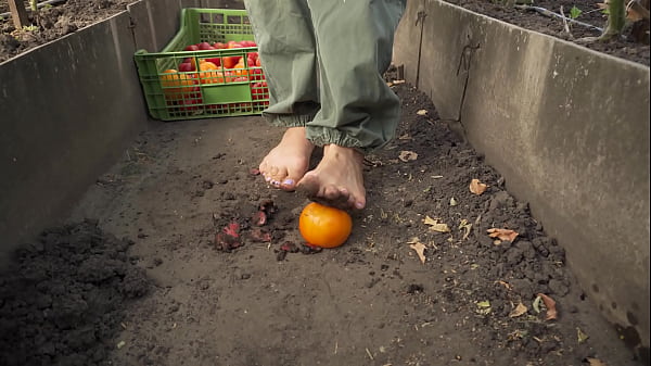 Dirty feet crushing vegetables outdoors 