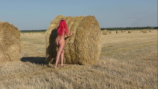 A naked girl moves rollers with hay 