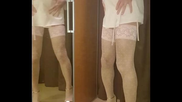 Man dressed in different sets of womans underwear and models it in front of the mirror 