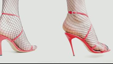 Feet In Black Fishnet Pantyhose Tights And Red High Heels