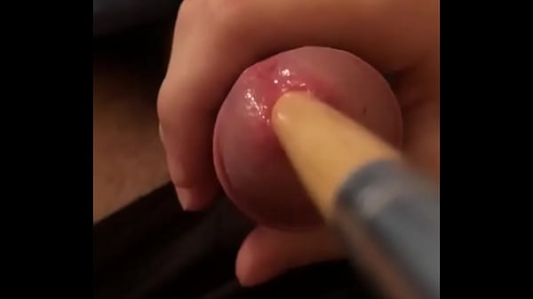 Inserting long wooden brush in cock 