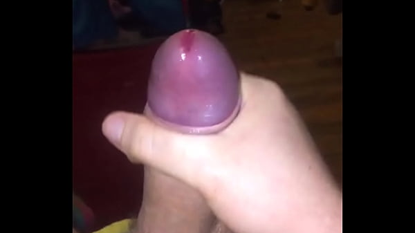 Bead of precum from a thick uncut cock