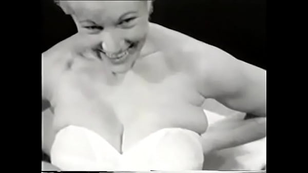 Sexy_blonde in a white corsetposes for the camera exposing her big tits to aphotographer from the 60s for amen s magazine