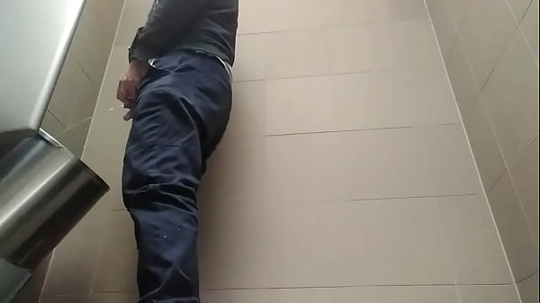 Young man peeing in a toilet 