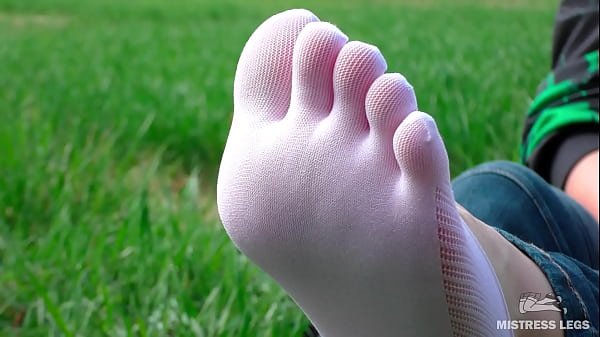 Goddess feet in cute white socks_with jeans on the springgrass field