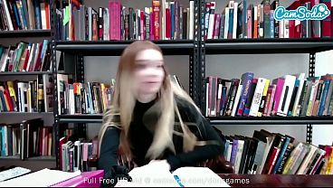 Redhead plays with her pussy on cam in library