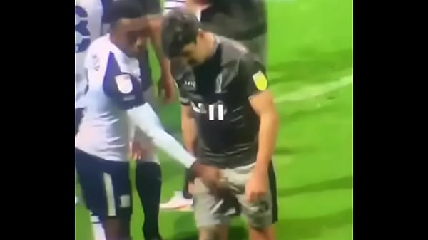 Pegando na rola do jogador no campo de futebol