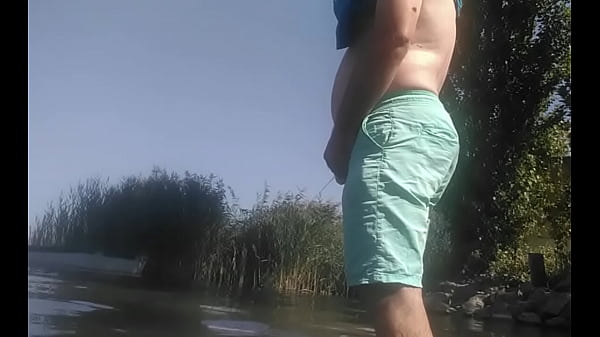 A guy with a soft, uncut dick urinates in nature 