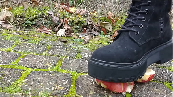 Woman crush apple underfeet 