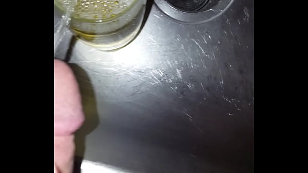 Strong golden piss into a cup 