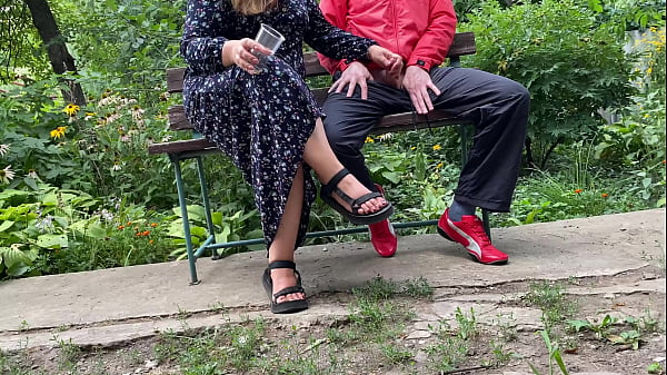 Hot MILF jerks off_a big dick into a glass in thepark on a bench