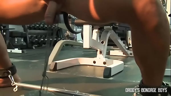 Muscular guy does squats with weights tied onto his nuts 