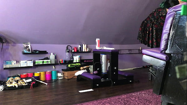 Dominatrix waxing man;s legs 