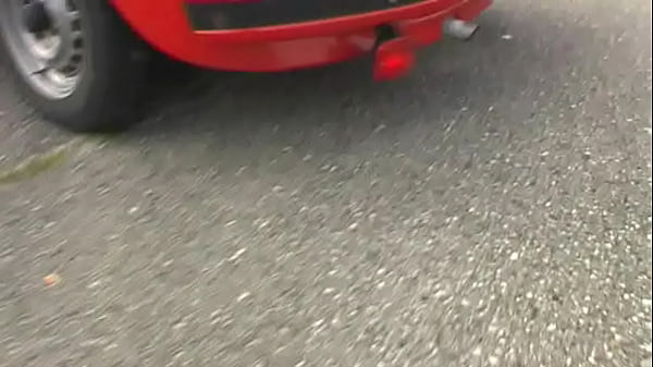 Bimba siting barefoot in her Volkswagen car revving the engine 