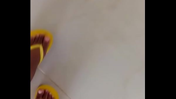 Sheis teasing withher bare feet wearing flip flops
