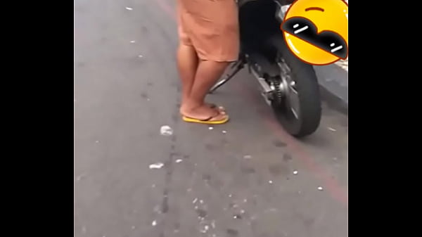 Dono da moto na avenida de camisa e bermuda 