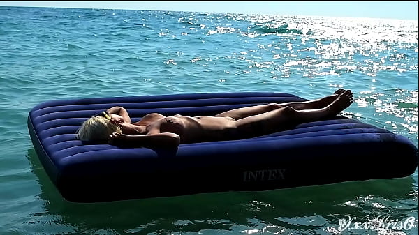 I spied on a nudist beach how a naked girl with big tits floats on a mattress and motion