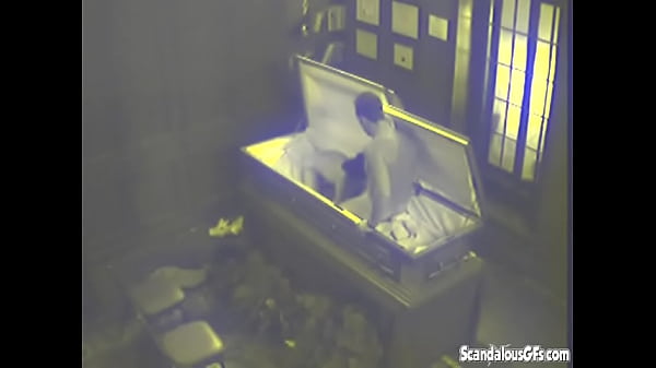 Two people having sex in a coffin before the service