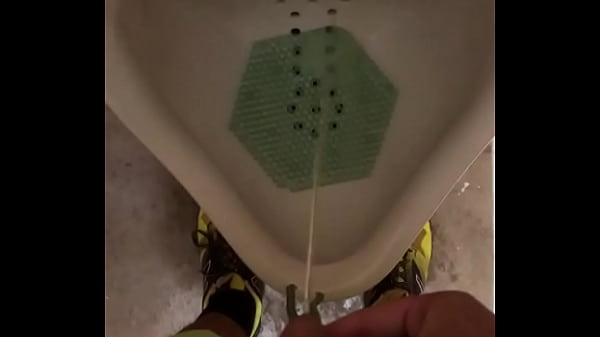 Male pees in urinal after workout