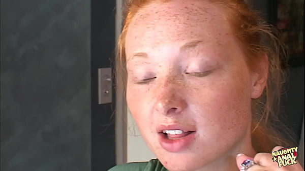 Following the act of engaging in sexual intercourse with two partners simultaneously this individual with red hair receives a kind of sexual activity known as bukkake in which several individuals ejaculate across her face