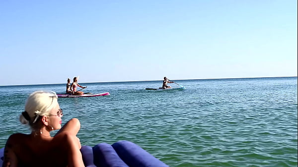 I spy on the beach as a girl with big boobs sunbathes in front of the public and dolphins