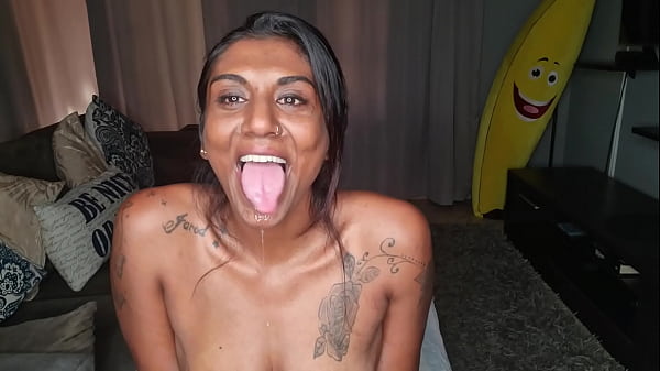 Desi sits_on the couch drooling as_she sticks out_and wiggles her_tongue around