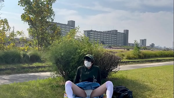 ニーハイの女装子まゆちゃんが遠くにたくさん人がいる河原で自撮り露出パンチラ撮影を楽しんでいる