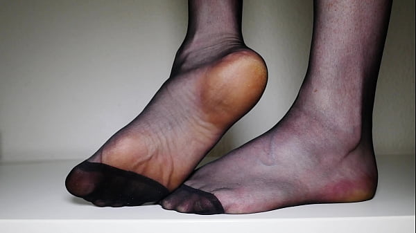 Feet in black pantyhose tights