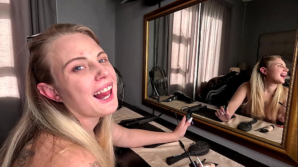 Sexy tattooed blonde girl doing her hair and makeup naked 