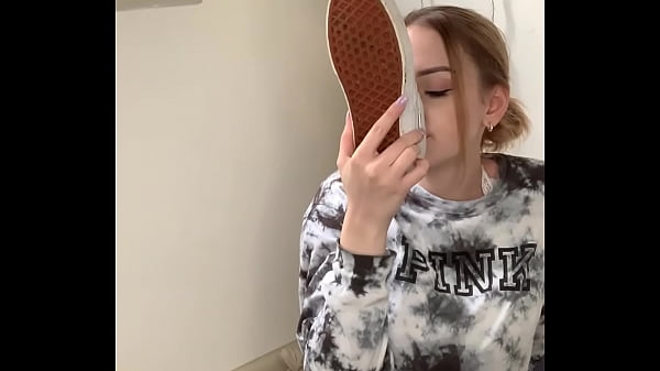 Garota tirando seus tênis e_mostrando seus pés descalços