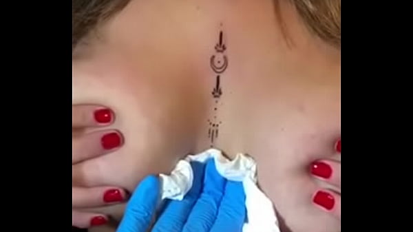 Loira com os peitos enorme mostrando sua tatuagem sem timidez