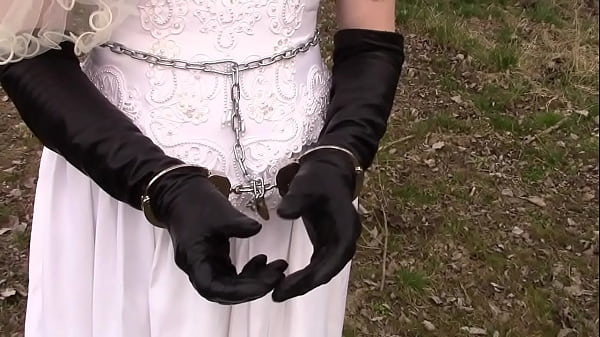 Handcuffed Woman In Wedding Dress And Long Leather Gloves thumbnail